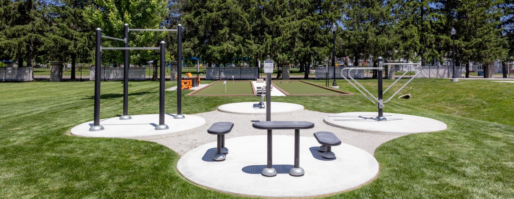 a large grassy area with a playground in the background